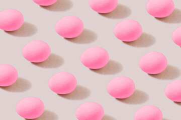 Pattern of pacific pink eggs on a cream background. The concept of minimal food.Easter eggs.
