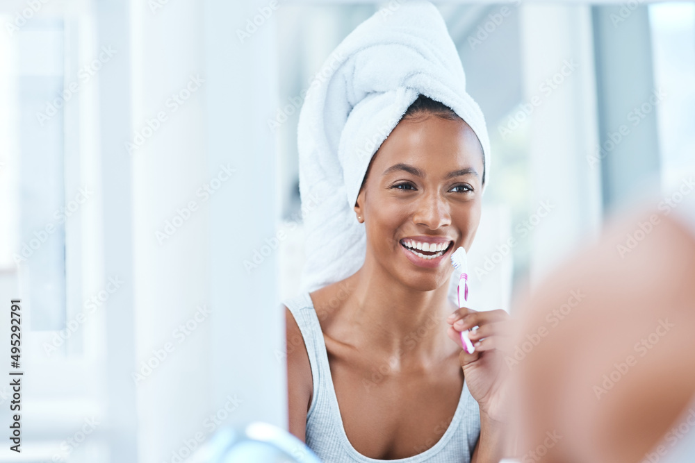 Wall mural i take care of my bright smile. cropped shot of an attractive young woman brushing her teeth in the 