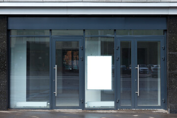 Vertical empty billboard on the glass facade of an empty office. Room rental template. Mock-up.