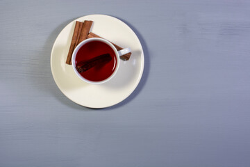 a cup of cinnamon tea and cinnamon sticks. overhead shot