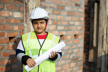 Portrait of school kid boy in Engineer dress costume concept of young boy in white safety helmet...