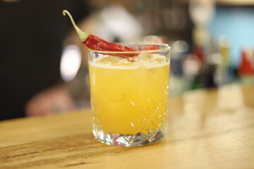 Alcoholic Cocktail with Lemon and Red Hot Pepper in the Bar