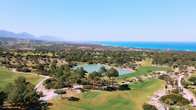 Aerial view of Golf Course with putting green grass and trees on golf field Fairway and putting green top view Amazing bird eye view over Golf courses in summer sunny day in Cyprus