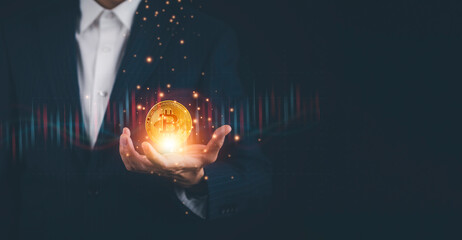 Businessman Hand hold bitcoins as part of a business network on Gold background. bitcoin cryptocurrency ideas concept and virtual financial chart diagram, Digital symbol of a new virtual currency