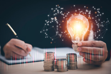 Woman hand hold light bulb with icons work on the desk, Creativity and innovation are keys success. Concept of new idea and innovation with icons and light bulbs, Save the money, Freedom of thought.