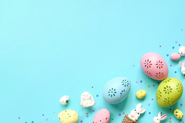 Easter composition. Easter eggs and easter bunny on pastel blue background. Minimal concept of Easter. Flat lay, top view, copy space.