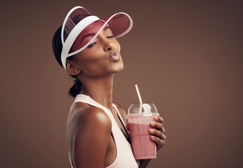 This smoothie makes me berry happy. Shot of an attractive young woman standing alone in the studio...
