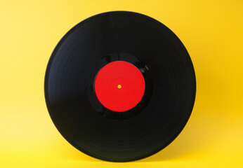 Old, retro, vinyl record disc close up on yellow background