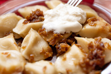 traditional polish and ukrainian food dumplings pierogi fillied with cottage cheese and potatoes covered with fried onion and served with cream east european dinner delicious and tasty vegetarian food