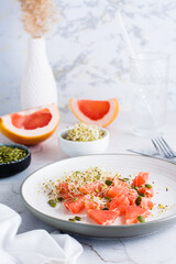 Fresh salad of grapefruit, clover and alfalfa sprouts and pumpkin seeds on a plate on the table. Organic vegetarian detox food. Vertical view
