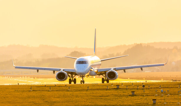 Passenger plane at the airport in the sunset. Summer travel by plane. Real photo. Beautiful natural sunlight.