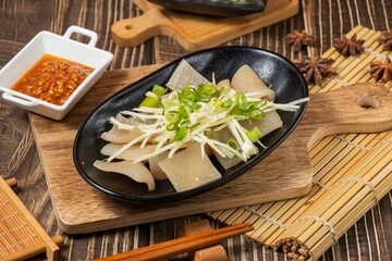 pig skin in a dish with chilli sauce isolated on wooden board side view on table taiwan food