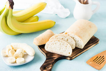 Fresh sliced banana bread and bananas on a plate on the table. Homemade baking.