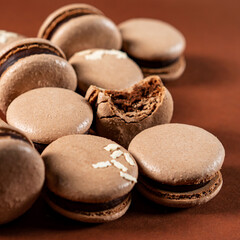 Some sweet tasty brown macarons dessert against a monochromatic brown background.
