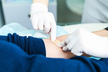 doctor sticking a band-aid after blood sampling