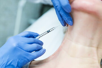 doctor cosmetologist makes an injection with plasma into the skin of the neck. anti aging...