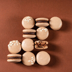 Some sweet tasty brown macarons dessert against a monochromatic brown background.