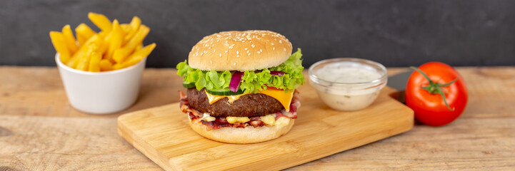 Hamburger Cheeseburger fastfood fast food with French Fries on a wooden board panorama