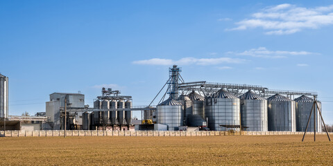 panorama view on agro silos granary elevator on agro-processing manufacturing plant for processing drying cleaning and storage of agricultural products, flour, cereals and grain. © hiv360