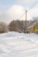Snow-covered village streets in winter. Frosty morning. Vertical image