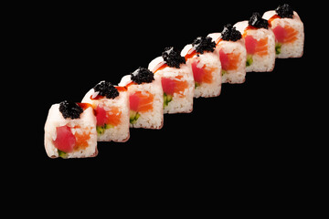 sushi roll with salmon, tuna, black tobiko caviar, cucumber, soy paper, unagi sauce. isolated on black background.