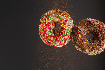 Two donuts on a gray background. Levitation. Holiday, birthday, anniversary, romantic breakfast. Restaurant, hotel, cafe, confectionery, supermarket. Banner.