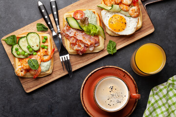 Breakfast waffles with fried eggs, salmon, cucumber and prawns