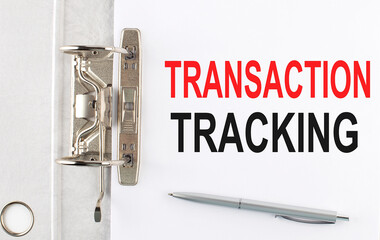 TRANSACTION TRACKING text on the paper folder with pen. Business concept