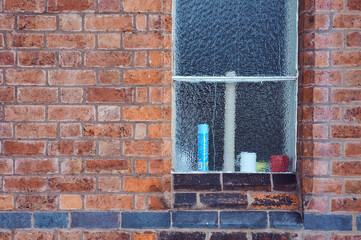 pattern background image of frosted window on old redbrick wall with line of black bricks