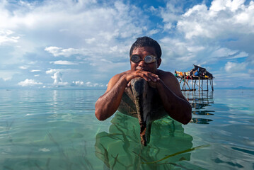Portrait of Bajau Laut or Sea Gypsy man on a boat with scuba glass in Maiga island Semporna Sabah...
