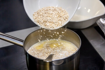 Cook cooks oatmeal porridge, adds grits to milk
