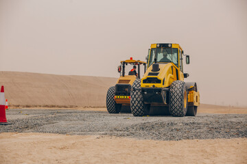 Fototapeta na wymiar Dozer, excavator, and road rollers working on the mud site