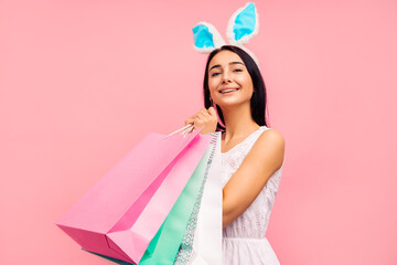 Beautiful woman in rabbit ears with shopping bags in her hands, spring shopping, a traditional holiday
