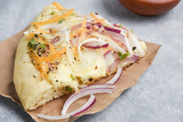 porcion de pizza con cebolla morada y queso