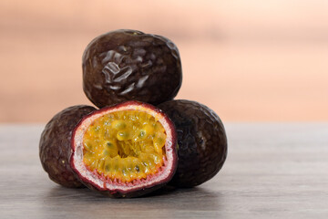 Purple maracuya,passion fruit on a wooden board, front view for background or wallpaper. Fresh...