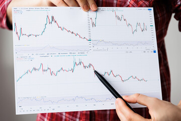 close up of a Plan Analyst are analyzing data from graphs in order to improve their performance. the movement of currencies and predicts the development of the situation