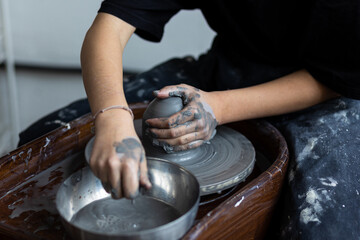 Young woman doing handmade pottery on the potter's wheel. Artist at work