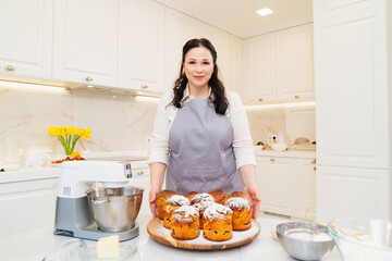 female cook with Kraffins, easter cakes and Panettones in the kitchen.