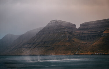 Faroe Islands, Kalsoy island near Husar village in sunset light durig twilight with pink sky and cliffs. November 2021