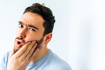 close up of a young american man touching mouth with hand with painful expression because of...