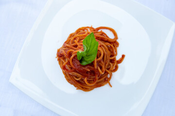 delicious spaghetti with tomato sauce in a white dish