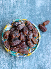 Dried dates on a blue ceramic plate. Close up photo of sweet dates on a table. healthy eating concept. 