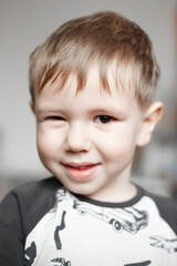 Fototapeta premium Little Caucasian boy smiling and looking at camera, lifestyle photography