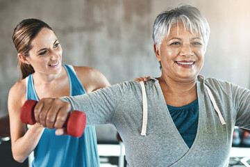 The healthy heart is a youthful heart. Shot of a senior woman using weights with the help of a...