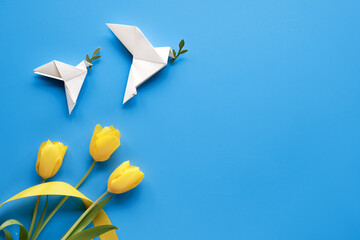 Dove of peace, paper origami. Peace to Ukraine. Yellow tulips, flowers, on blue background....