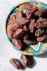 Dried dates on a blue ceramic plate. Close up photo of sweet dates on a table. healthy eating concept. 