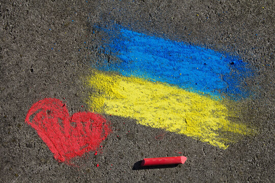 Flag of Ukraine and pink heart. Chalk drawing on sidewalk. Support for Ukraine.