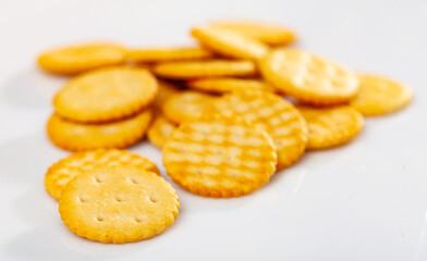 Heap of crispy disc-shaped lightly salted crackers on white background. Traditional popular snack..