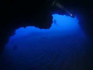 cave diving underwater scuba divers exploring caves and having fun ocean scenery sun beams and rays background