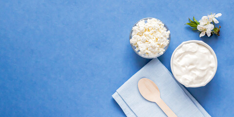 Top view to cottage cheese and sour cream on blue background.